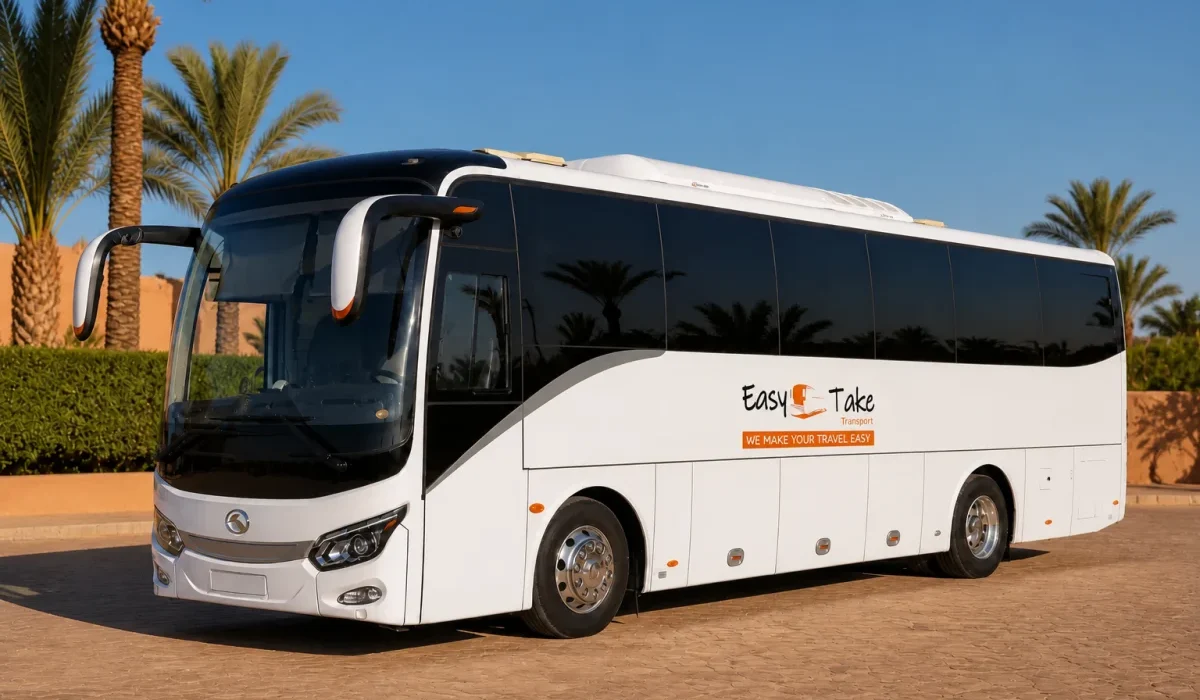 Pristine EasyTake-branded King Long luxury coach in a palm-lined Marrakech fleet yard