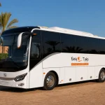 Pristine EasyTake-branded King Long luxury coach in a palm-lined Marrakech fleet yard