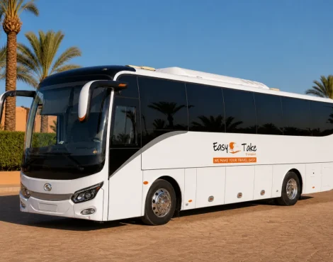 Pristine EasyTake-branded King Long luxury coach in a palm-lined Marrakech fleet yard