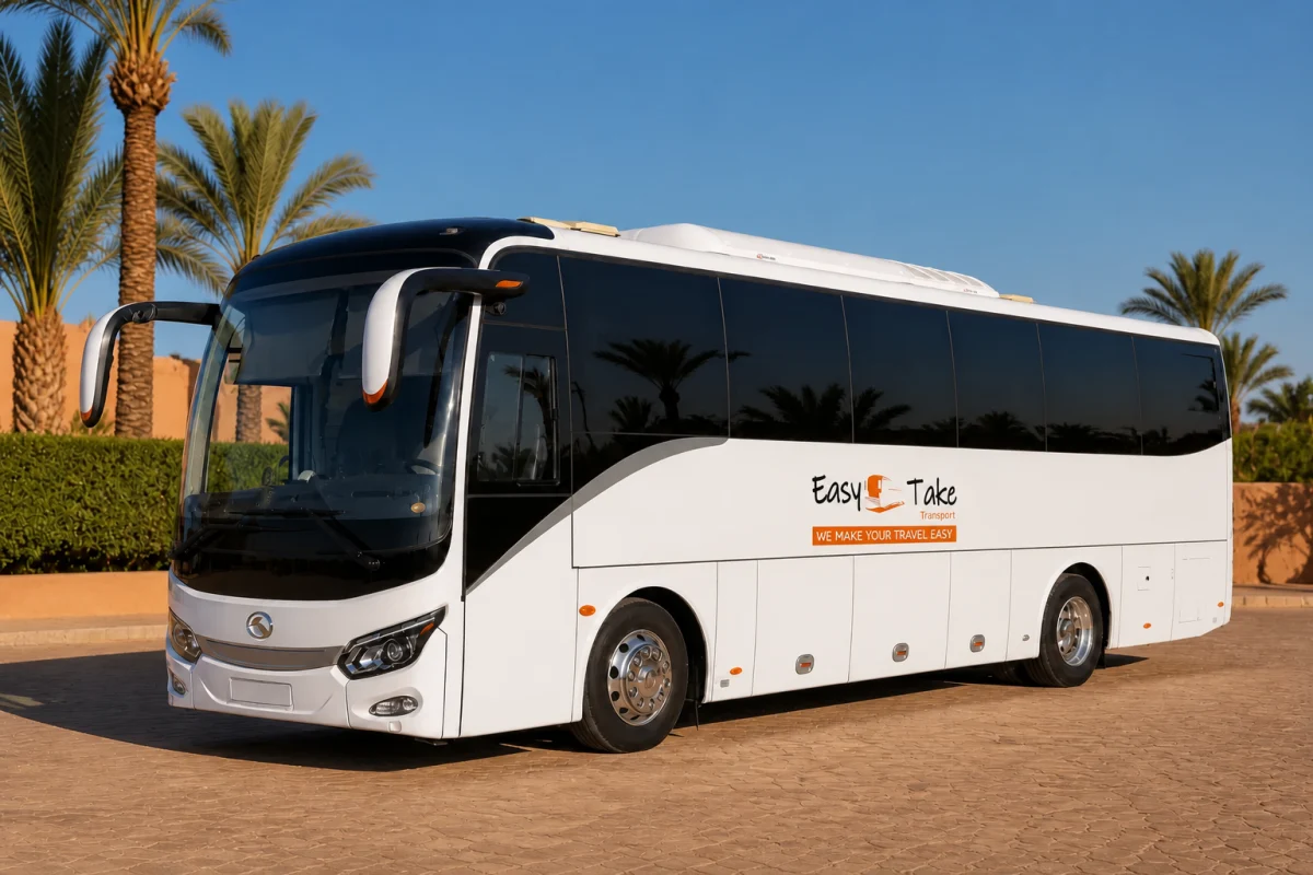 Pristine EasyTake-branded King Long luxury coach in a palm-lined Marrakech fleet yard