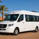 Pristine white Mercedes Sprinter passenger minibus in a palm-lined Marrakech fleet yard
